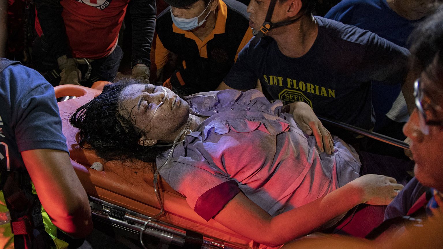 Image: Paramedics carry away an earthquake survivor in Porac