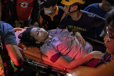Paramedics carry away a survivor who was rescued from the debris in Porac on Tuesday.