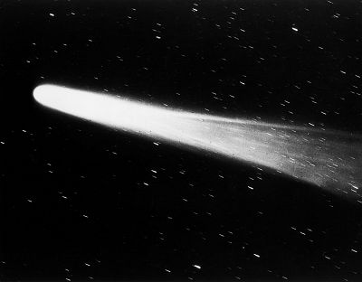 Close view of Halley\'s comet streaking past stars in the night sky.