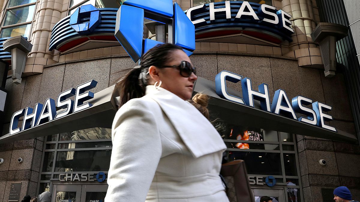 A woman passes by a Chase bank in Times Square in New York