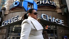 A woman passes by a Chase bank in Times Square in New York