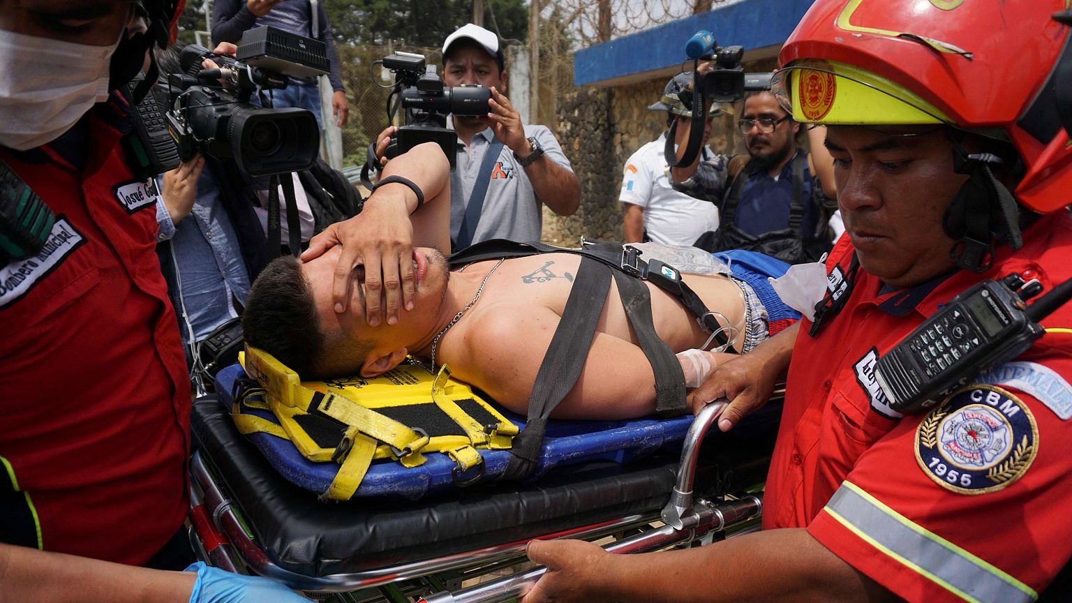Image: An injured inmate is carried away on a stretcher