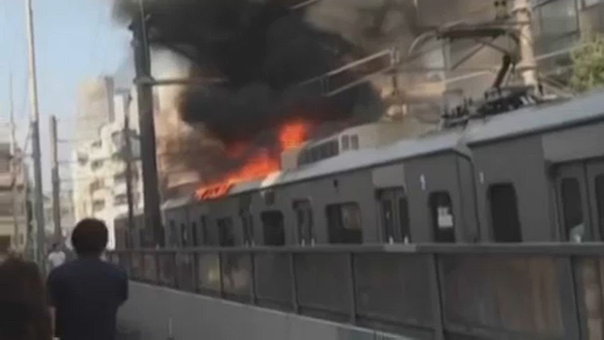 Brennender Passagierzug fährt durch Tokio
