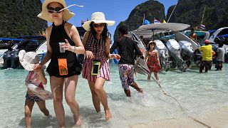 Image: Tourists get off a speedboat onto Maya Bay, on the southern Thai isl