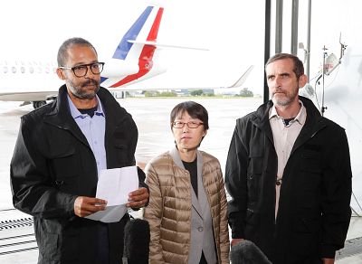 Freed French hostages Laurent Lassimouillas, left, and Patrick Picque, right, stand next to a South Korean counterpart who was not immediately identified after arriving at an airport near Paris on Saturday.