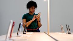 Image: An Apple Store employee uses an iPhone during the grand opening and 