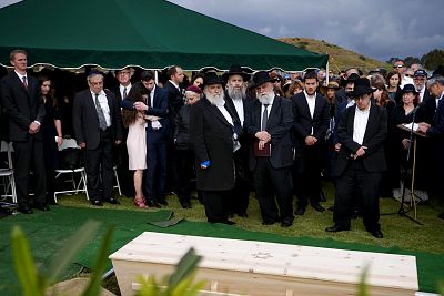Hannah Kaye, along with Jewish community leaders and mourners, stands near the coffin of her mother, Lori Kaye, at El Camino Cemetery in San Diego, California, on April 29, 2019. Lori Kaye was fatally shot at a synagogue in Poway.
