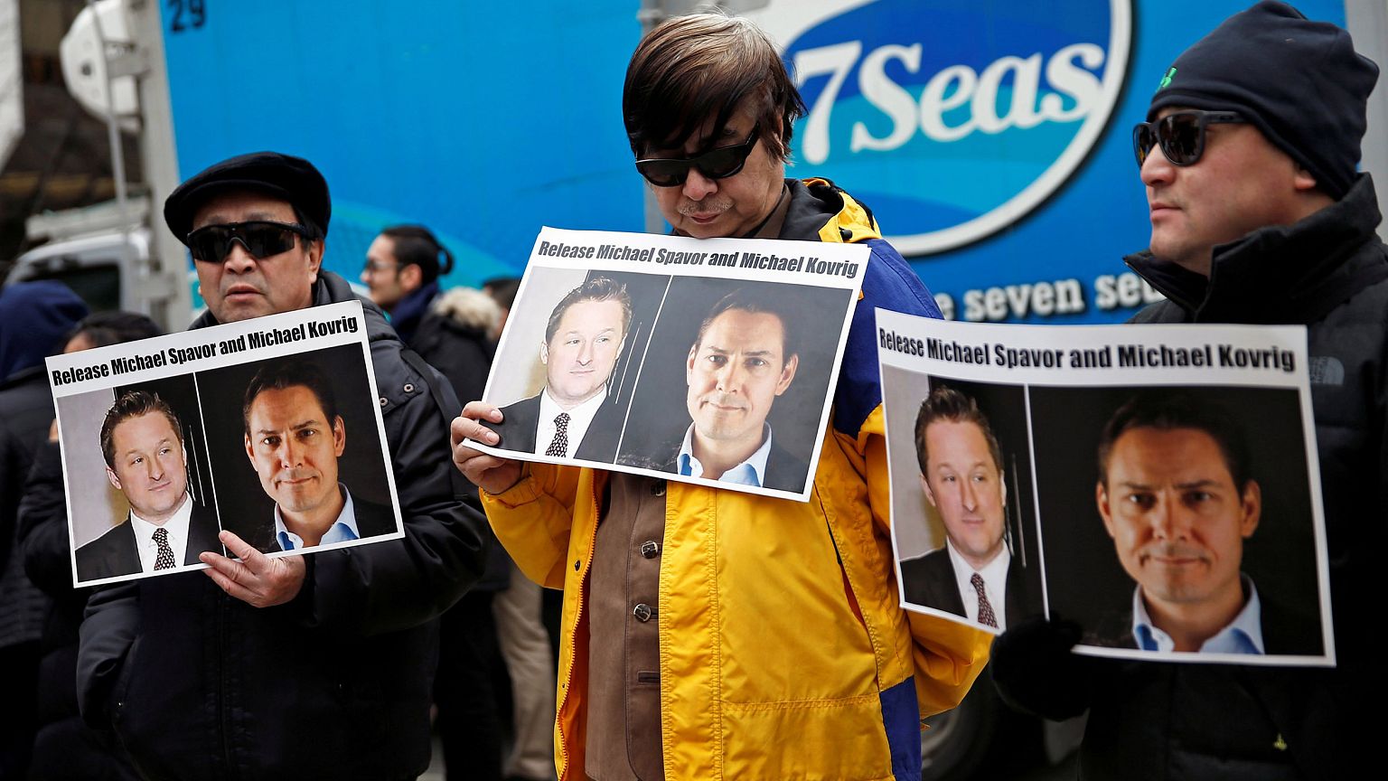 Image: People hold placards calling for China to release Canadian detainees