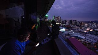 Image: Journalists use their smartphones during a power cut in Caracas, Ven