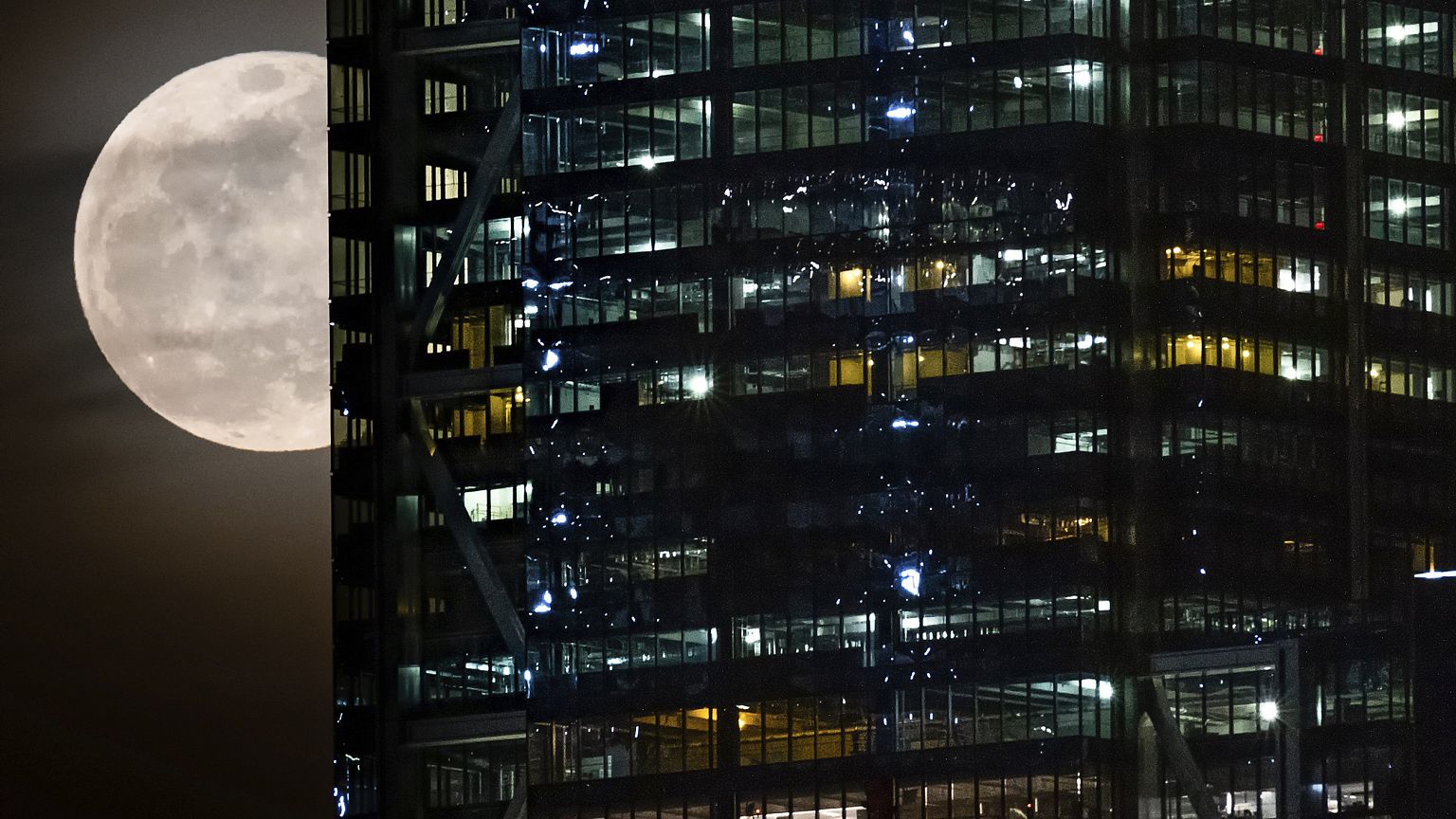 Image: The full moon passes behind the World Trade Center in New York