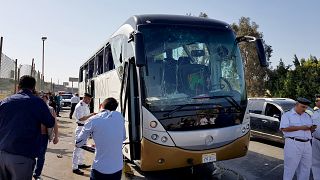 Image: A damaged bus near the site of a blast near the Giza pyramids in Cai