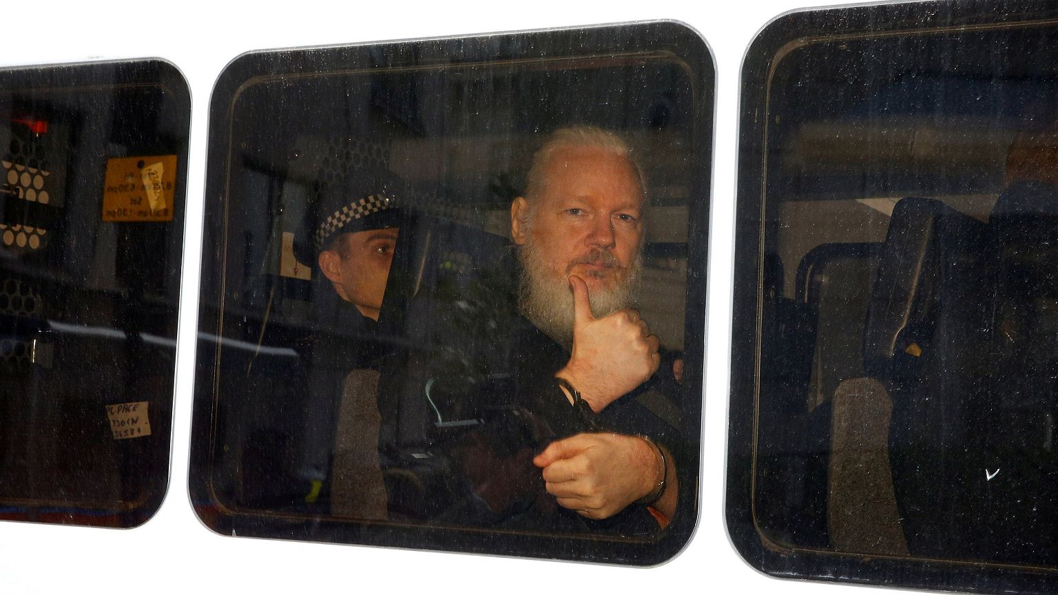 Image: WikiLeaks founder Julian Assange in a police van after was arrested 