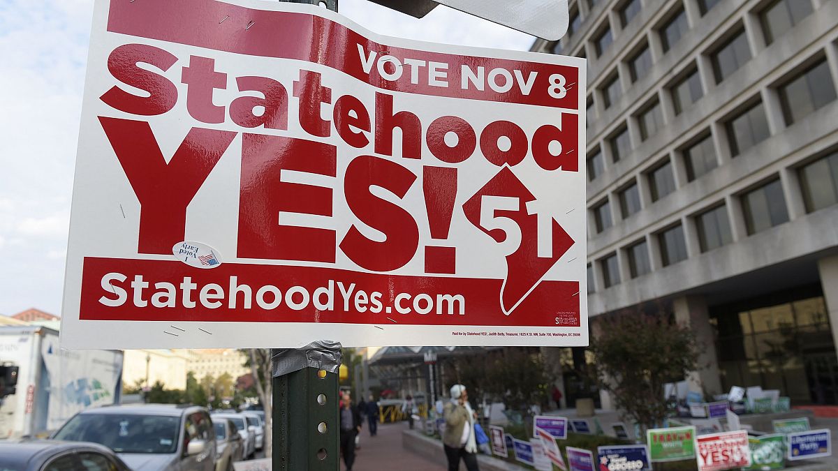 Image: Signs supporting DC statehood are on display outside an early voting