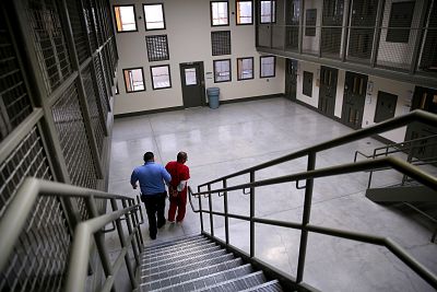 A guard escorts an immigrant detainee from his segregation cell back to general population at the Adelanto Detention Facility in California on Nov. 15, 2013.
