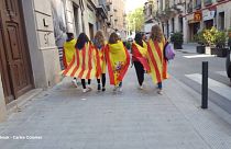 6 Mädchen mit Fahnen von Katalonien und Spanien - Welche Geschichte steckt dahinter?