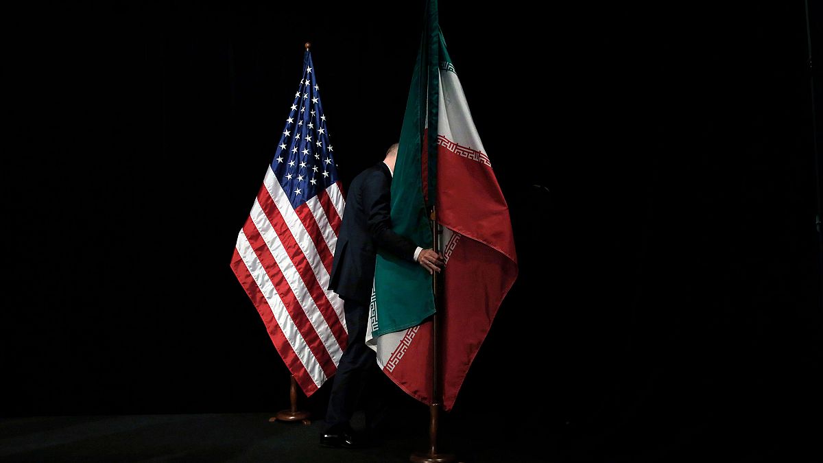 Image: A member of staff removes the Iranian flag from the stage after a gr
