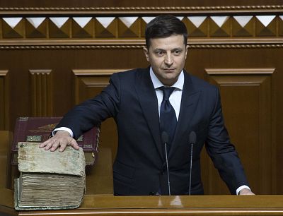 Volodymyr Zelenskiy swears on a Bible as he takes the oath of office on May 20.