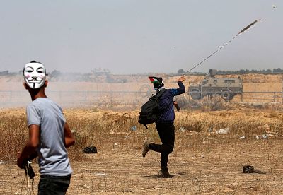 Palestinian demonstrators hurl rocks at Israeli soldiers in the Gaza Strip on May 15.