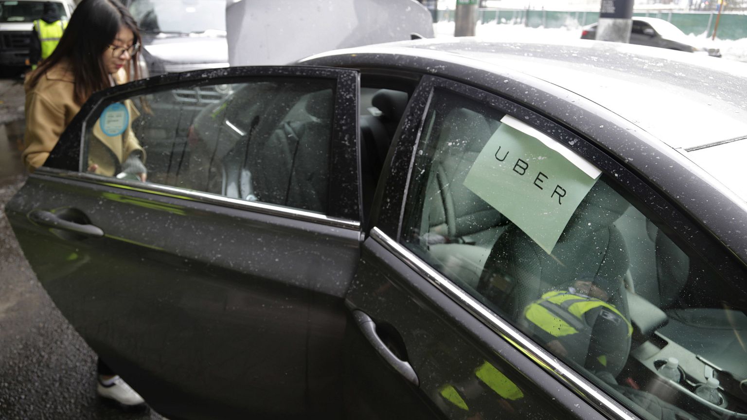 Image: A passenger enters an Uber car at LaGuardia Airport in New York