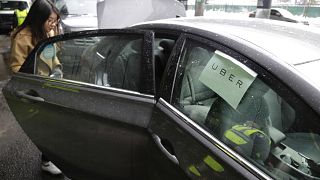 Image: A passenger enters an Uber car at LaGuardia Airport in New York