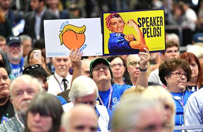 A woman holds up signs as US Speaker of the House Nancy Pelosi takes the stage during the 2019 California Democratic Party State Convention at Moscone Center in San Francisco on June 1, 2019.