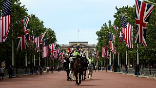 Image: Police officers ride horses on The Mall near Buckingham Palace befor