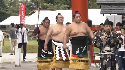 A sumo grand champion performs ring-entering ceremony in Japan