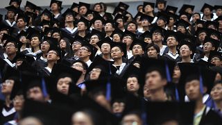 Image: Students attend their college graduation ceremony at Fudan Universit