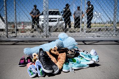 Security personal stand before shoes and toys left at the Tornillo Port of Entry in Tornillo, Texas on June 21, 2018.