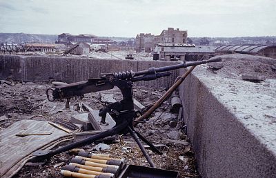 An abandoned German machine gun, and ammunition case on the roof of a building in the wake of the D-Day invasion by Allied forces, Arromanches-les-Bains, France.
