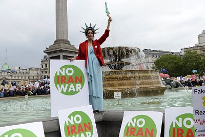 A protester holds a placard that says no iran war during the Anti-Trump protest in London on June 4, 2019.