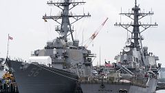 Image: The USS John S. McCain (DDG 56) destroyer, left, is moored in a dock