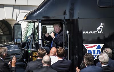 President Donald Trump jumps up in the cab of an 18 wheeler truck while meeting with truckers and CEOs regarding healthcare on the South Lawn of the White House on March 23, 2017.