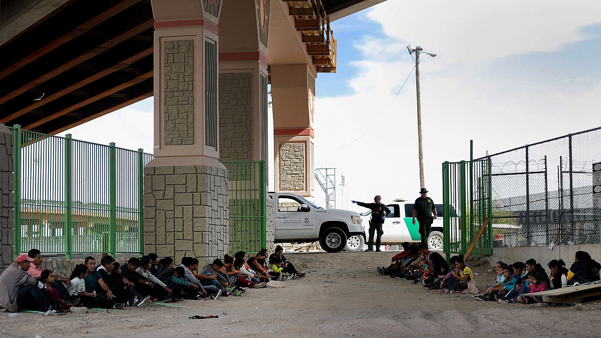 Image: Border Patrol agents watch over detained migrants near El Paso, Texa