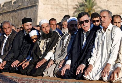 Fayez al-Sarraj, prime minister of Libya\'s Government of National Accord, in sunglasses, performs Eid al-Fitr prayers at the Martyrs Square in Tripoli on June 4, 2019.