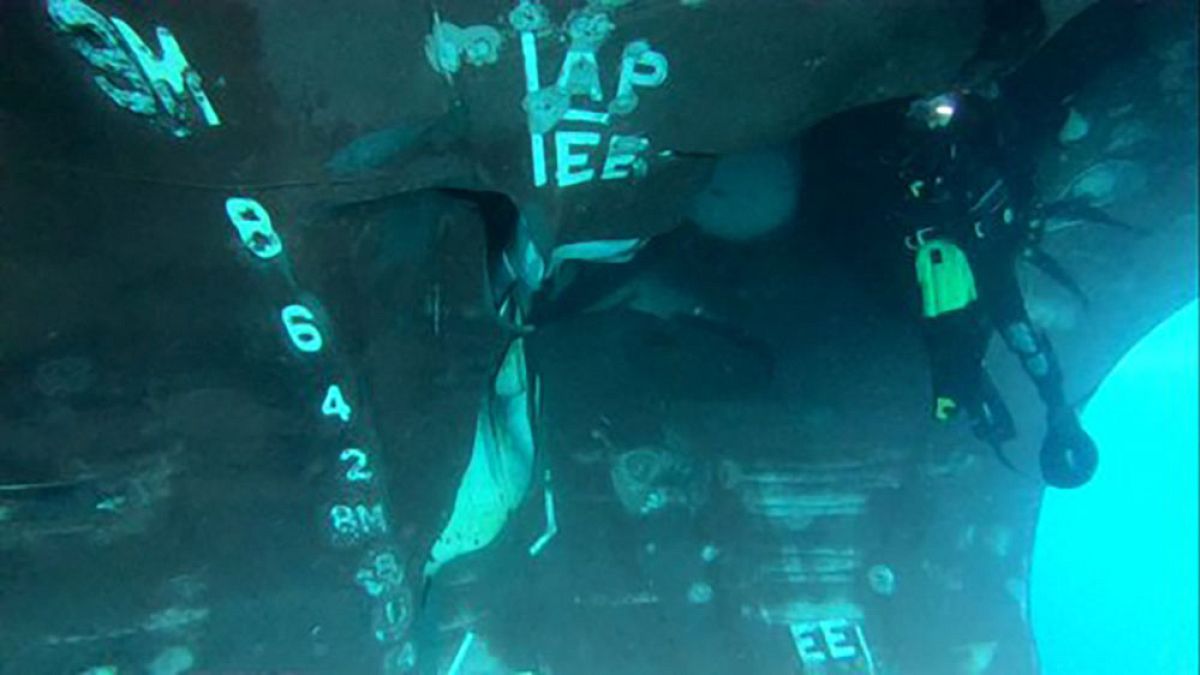 Image: A diver investigates the damage done to the Saudi-owned oil tanker A