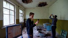 Image: Visitors take pictures at a kindergarten in the abandoned village of