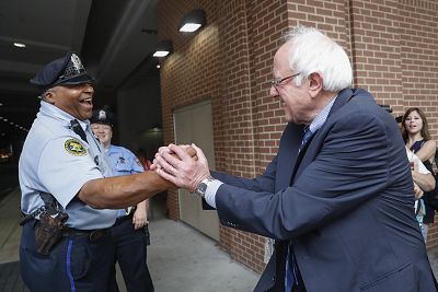 Sen. Bernie Sanders, I-Vt. greets a police officer during walk around downtown in Philadelphia on July 28, 2016, during the final day of the Democratic National Convention