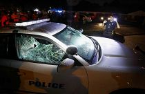 Image: A Memphis police officer looks over a damaged squad car after protes