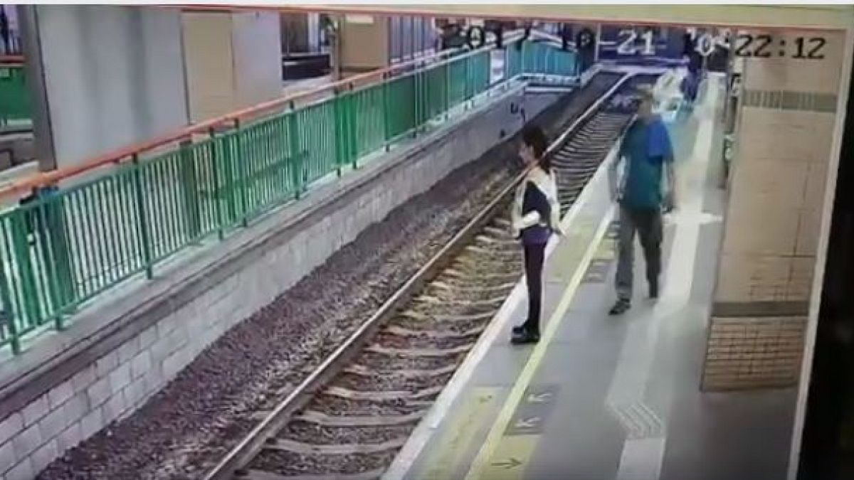 بالفيديو: رجل يدفع سيدة من على رصيف السكة الحديدية