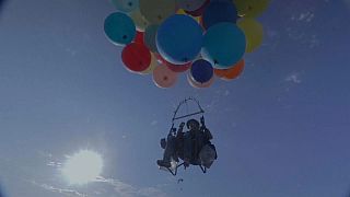 Accroché à des ballons gonflés à l'hélium