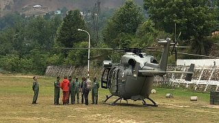 Image: Rescue mission team members stand next to an India Air Force (IAF) h