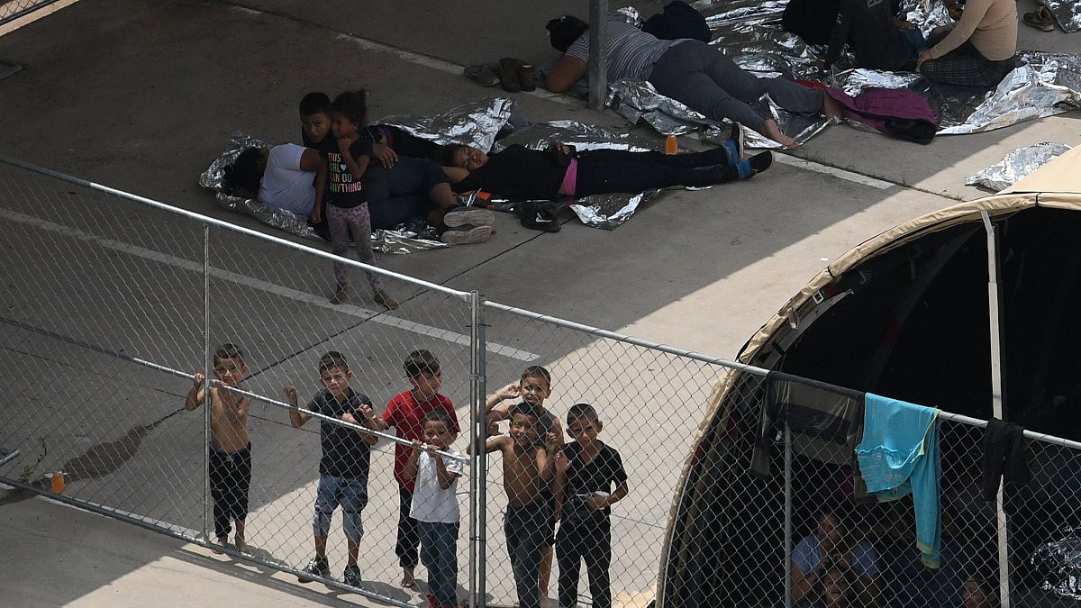 Image: Migrants are seen outside the U.S. Border Patrol McAllen Station in 