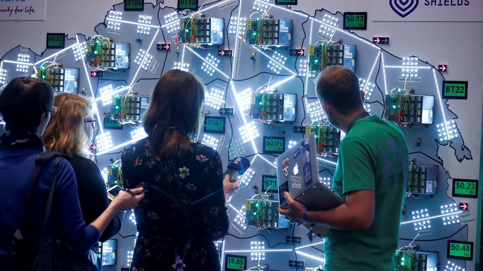 Image: People look at visualizations at a cyber defense exercise organize b