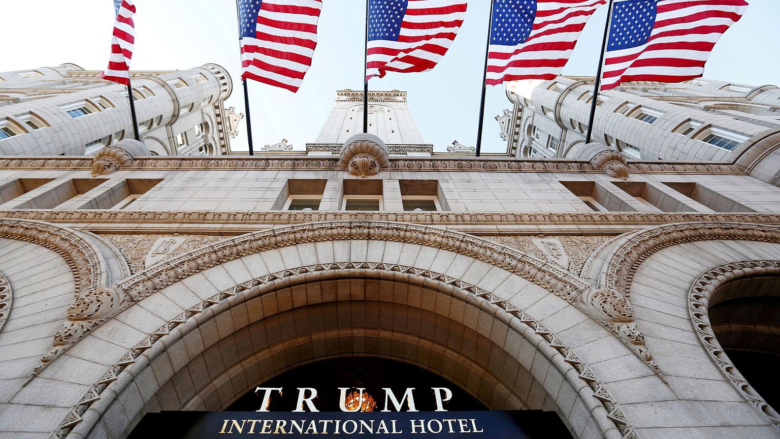 Image: Flags fly above the entrance to the new Trump International Hotel on