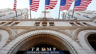 Image: Flags fly above the entrance to the new Trump International Hotel on