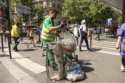 Abdel Hamid tries to stay out of the sun while picking up trash in Paris.