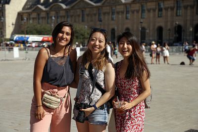 Laura Marquez, left , Mina Park and Ariel Min make a short stop at the Louvre Museum in Paris on June 29, 2019, before going to find shade in the heat wave.