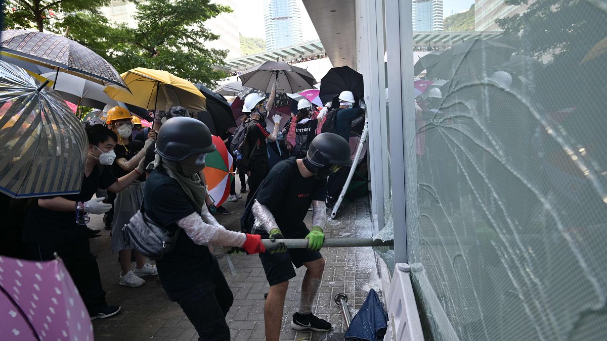 Image: Protesters attempt to break a window at the government headquarters 