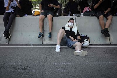 A protester rests against a road divider outside the Legislative Council in Hong Kong.